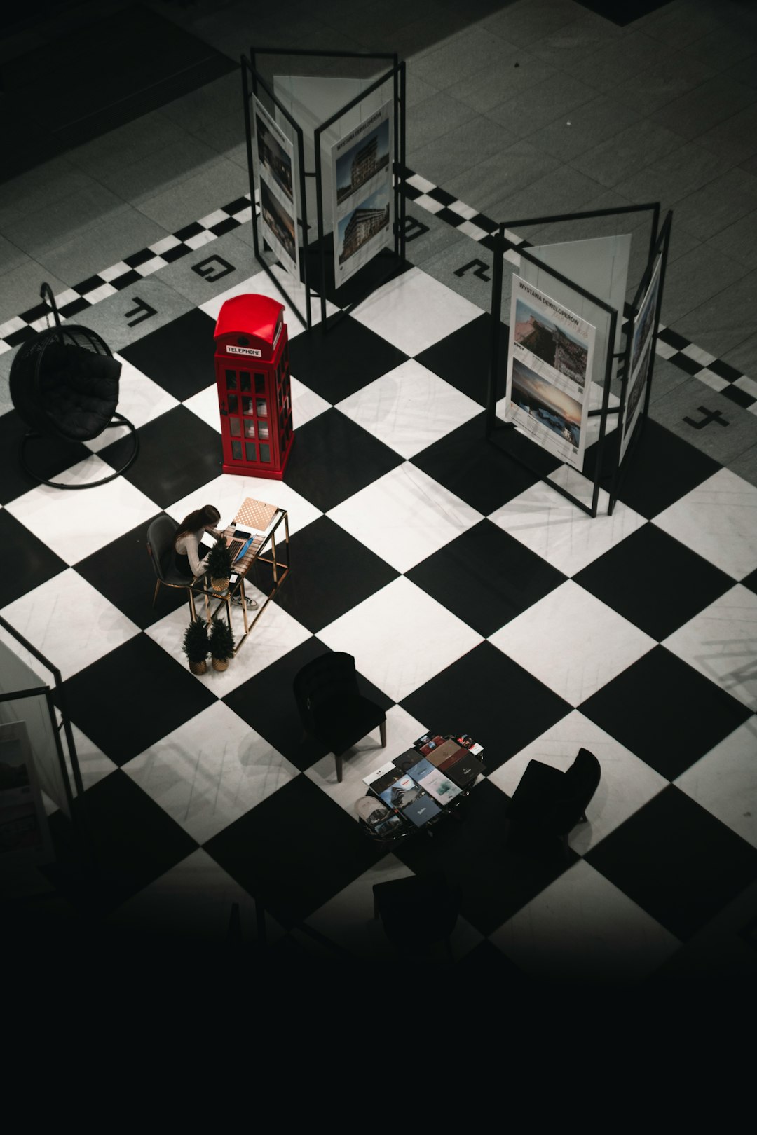 a-black-and-white-checkered-floor-with-a-red-phone-booth-tlwdpe2a1h4